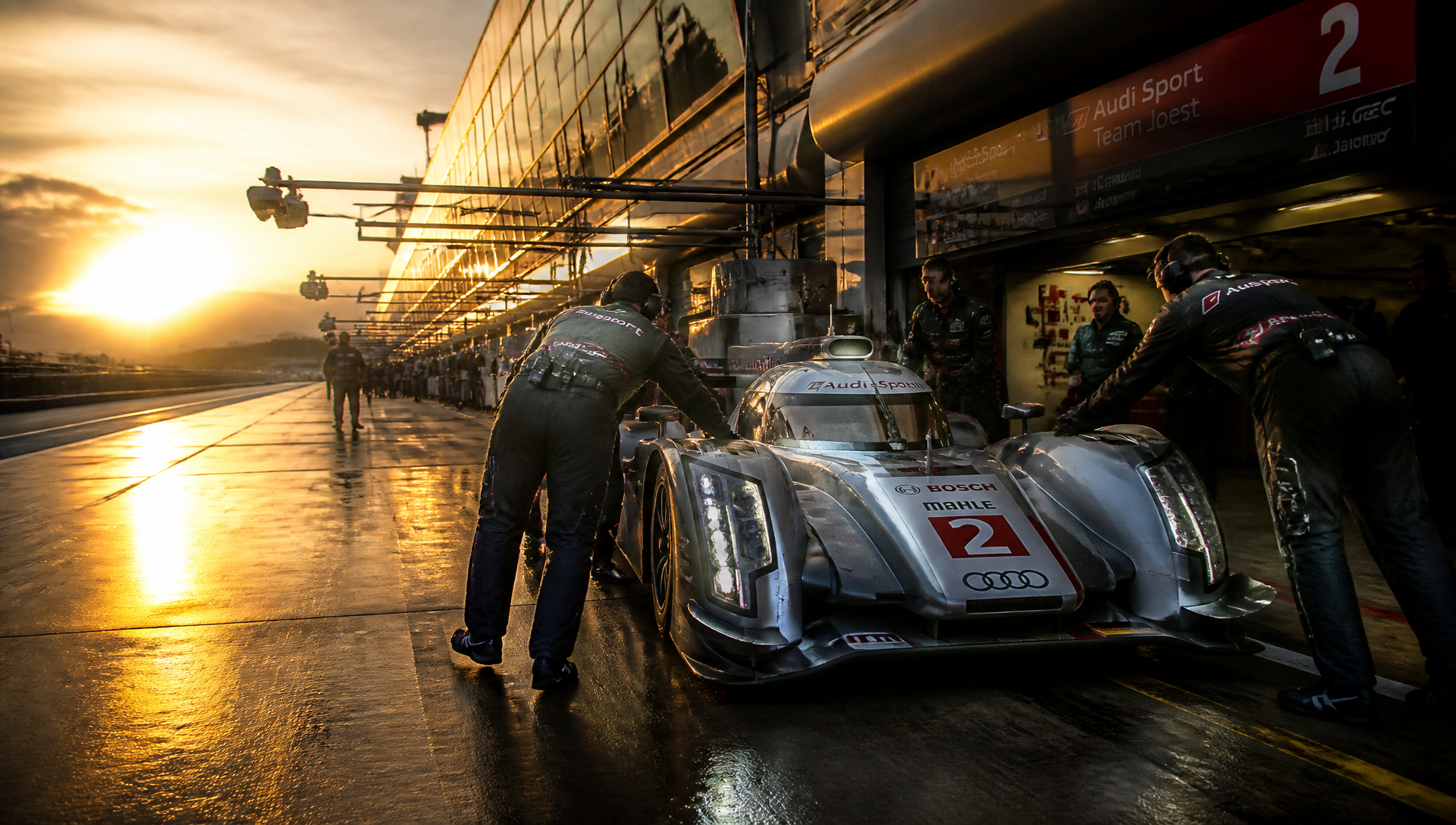 Mechanics roll a prototype out of the garage bay at dawn
